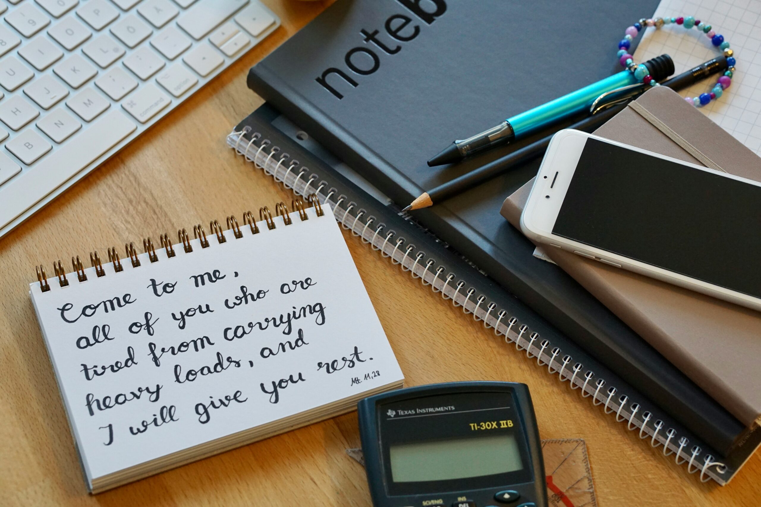 notebook with calculator on desk unsplash